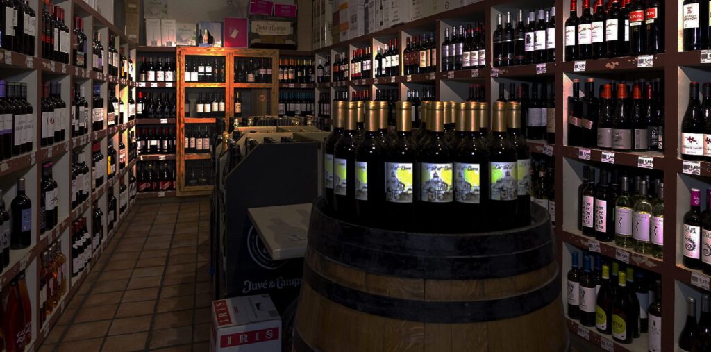 Bodega de vinos con estanterías de botellas y barrica central